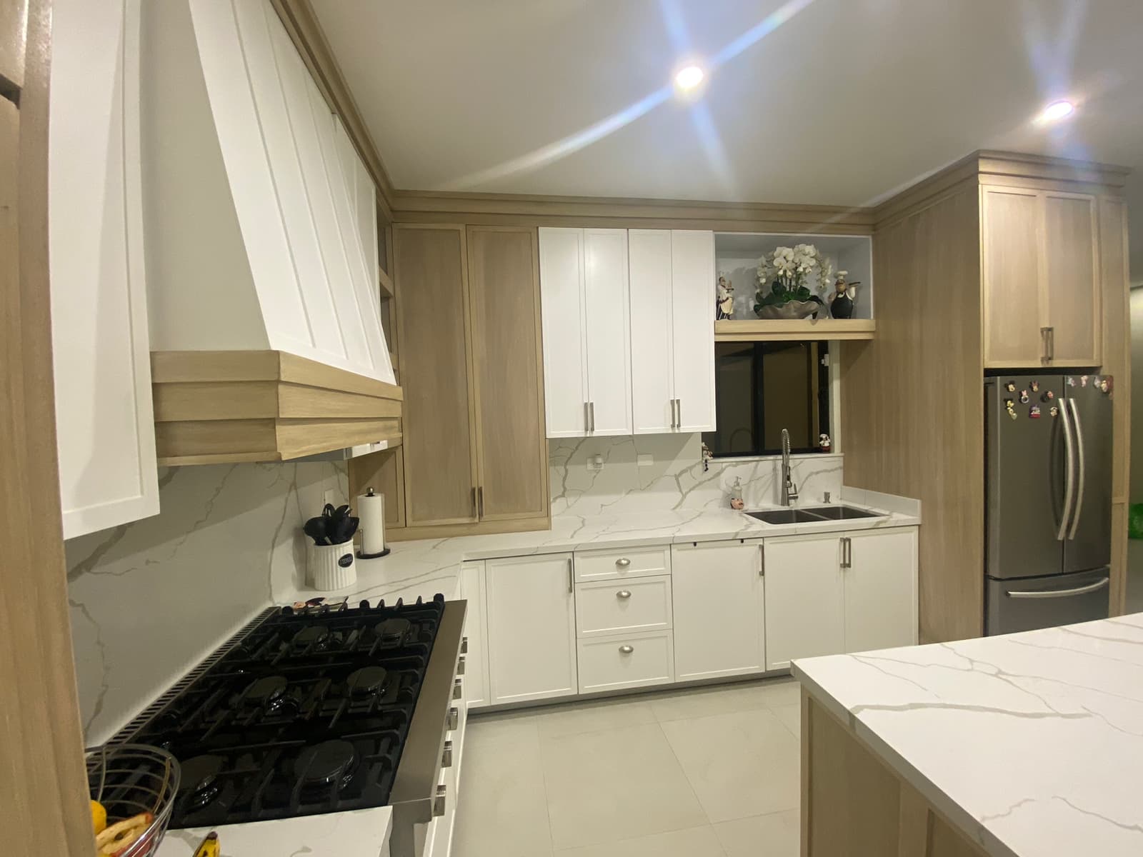 Modern minimalist white concrete residence with large glass windows surrounded by green landscaping